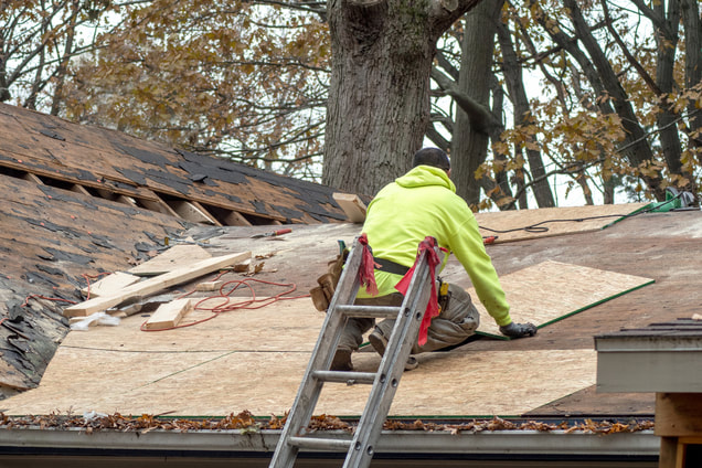 Picture of a man doing roof tear off of an old roof